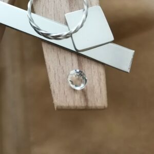 The pale yellow citrine round displayed on a jewellers bench peg with some sterling silver sheet and wire.