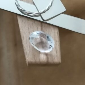 The clear quartz oval displayed on a jewellers bench peg with some sterling silver sheet and wire.