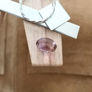 The purple and yellow ametrine oval displayed on a jewellers bench peg with some sterling silver sheet and wire.