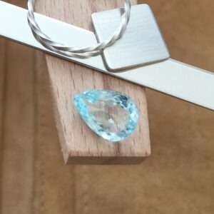 The large aquamarine teardrop displayed on a jewellers bench peg with some sterling silver sheet and wire.